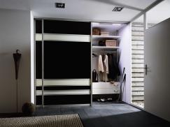 Kleiderschrank in schwarz und weißen Balken mit Gleittüren geöffnet