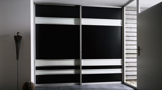 Kleiderschrank in schwarz und weißen Balken mit Gleittüren 