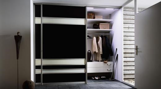 Kleiderschrank in schwarz und weißen Balken mit Gleittüren geöffnet