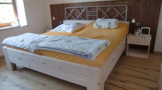 Bett aus Zirbenholz mit braunen Elementen