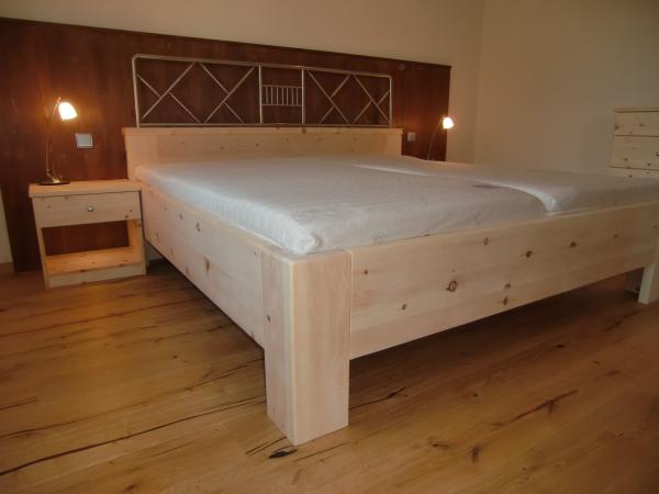 Bett aus Zirbenholz mit braunen Elementen 