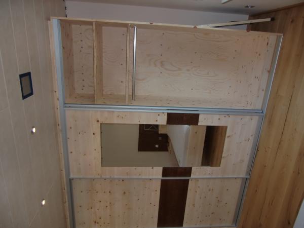 Kleiderschrank aus Zirbenholz mit braunen Elementen 
