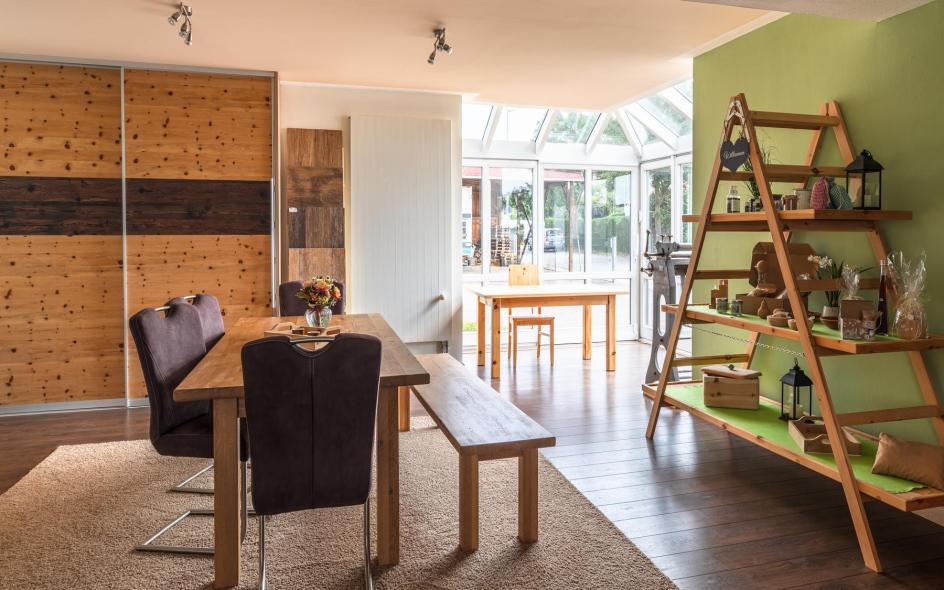 Ausstellung Holztisch mit Stühlen und Holzbank