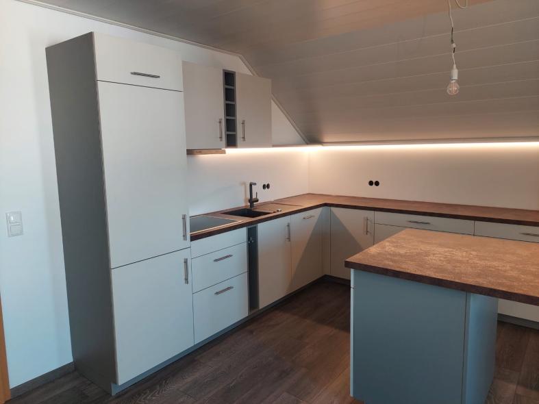 Küche in weiß mit Holzplatte und Beleuchtung