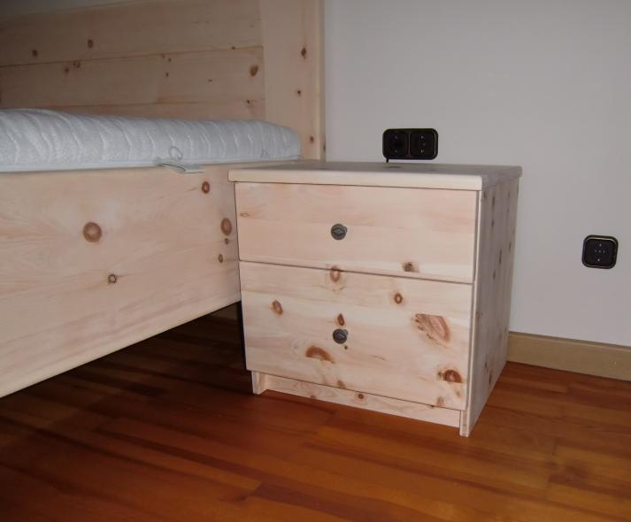 Zirbenschlafzimmer mit Bett und Nachttisch mit zwei Schubladen 