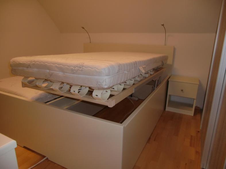 Schlafzimmer in creme-weiß mit Bett mit Bettkasten  