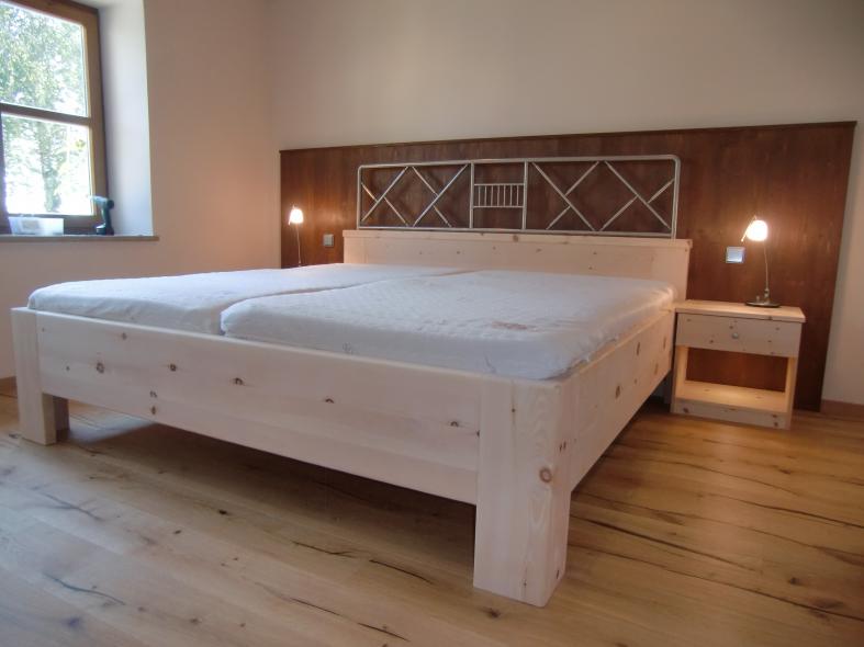 Bett aus Zirbenholz mit braunen Elementen