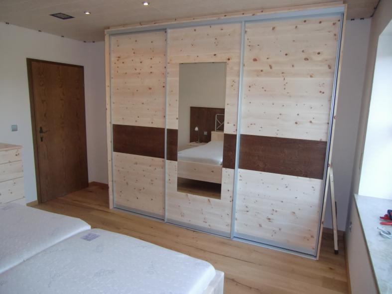 Kleiderschrank aus Zirbenholz mit braunen Elementen