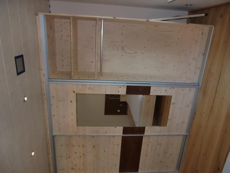 Kleiderschrank aus Zirbenholz mit braunen Elementen 