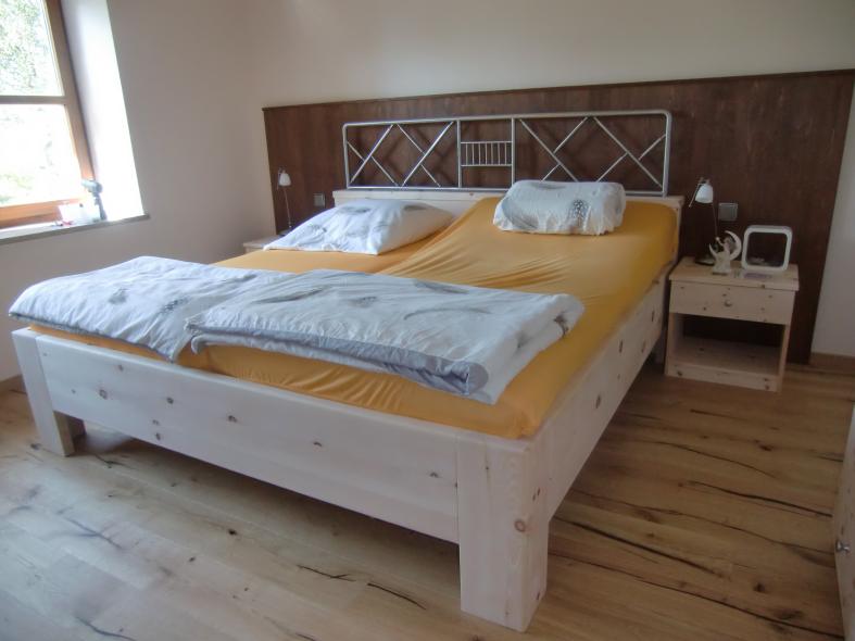 Bett aus Zirbenholz mit braunen Elementen 