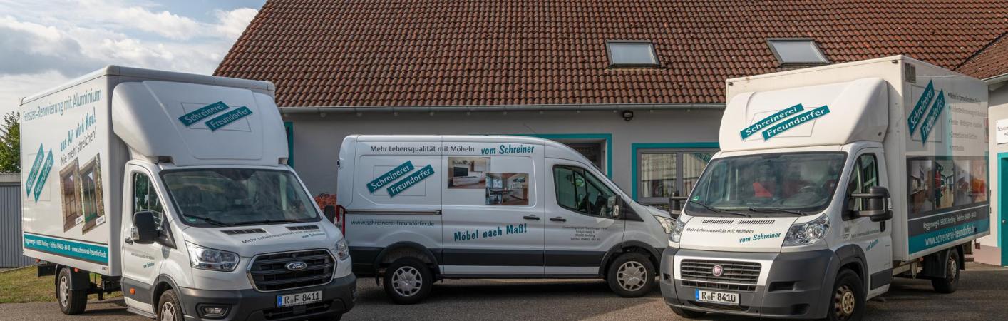 Firmengebäude mit Fahrzeugen mit Werbung